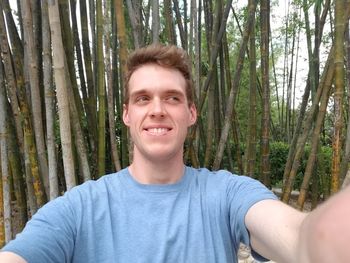 Portrait of smiling young man in forest