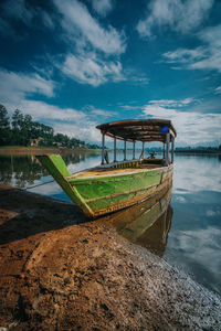 Abandoned boat on lake against sky