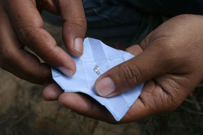 High angle view of hands holding paper