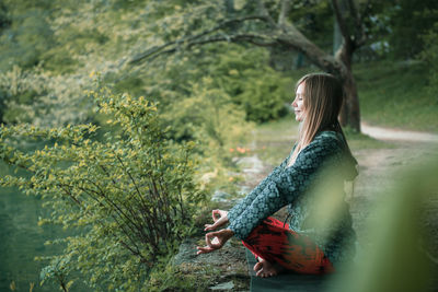 Woman doing yoga by lake