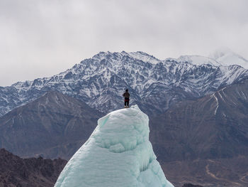 Man on snowcapped mountain against sky