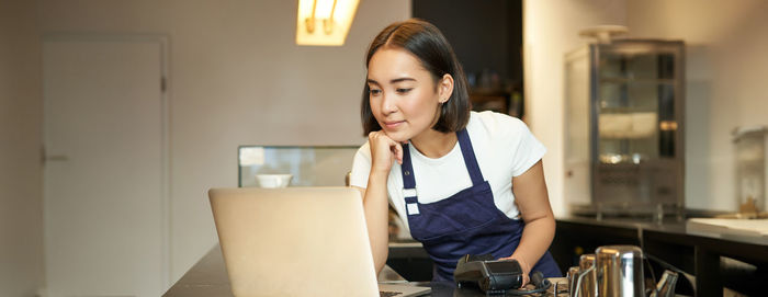 Young woman looking away while sitting at home