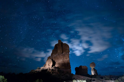 Low angle view of rocks against sky at night