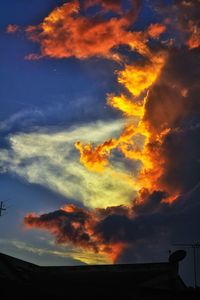 Low angle view of silhouette building against dramatic sky