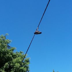 Low angle view of power lines against clear blue sky