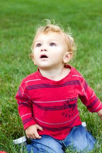 Portrait of cute baby girl sitting on grass