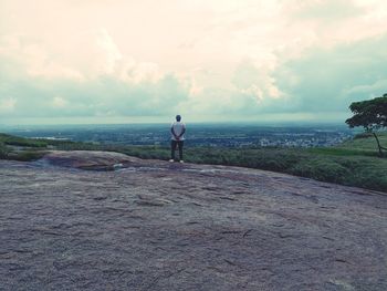 Rear view of man looking at sea against sky