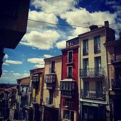 Low angle view of buildings against cloudy sky
