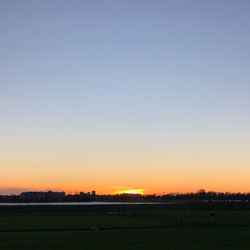 Scenic view of field against clear sky during sunset