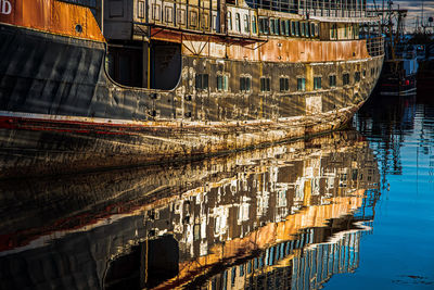 Aerial view of boats moored on river against buildings