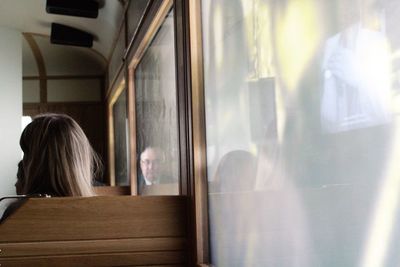Rear view of woman looking through window