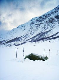 Tent on snow covered field against mountains