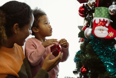 Rear view of girl and christmas tree