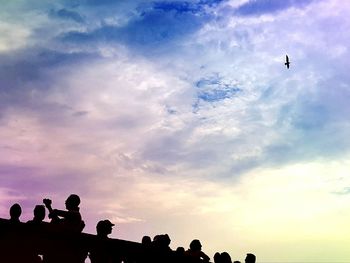 Low angle view of silhouette birds flying against sky