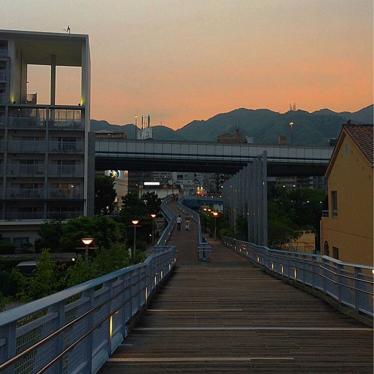 built structure, architecture, building exterior, railing, sunset, the way forward, clear sky, mountain, sky, connection, street light, bridge - man made structure, house, residential building, city, residential structure, outdoors, diminishing perspective, footbridge, orange color