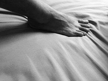 Low section of man lying on bed