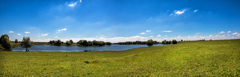 Scenic view of grassy field against cloudy sky