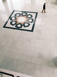 High angle view of man walking by pattern on floor