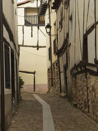 Empty narrow alley along buildings