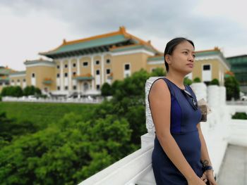 Young woman standing against sky