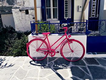 Bicycle parked on footpath by building in city