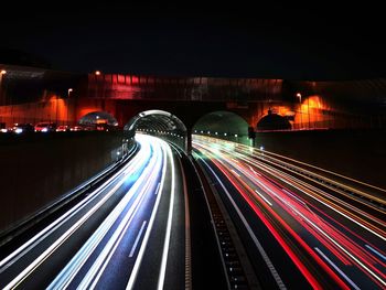 Light trails on bridge in city at night