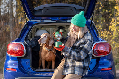 Rear view of woman standing in car