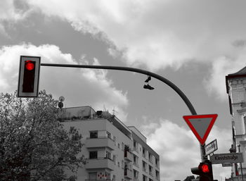 Road sign against cloudy sky