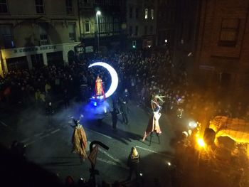 Crowd at illuminated city during night