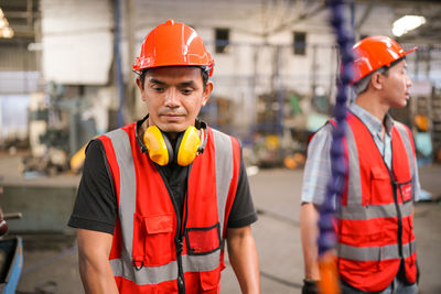 Industrial engineers in hard hats.work at the heavy industry manufacturing factory.