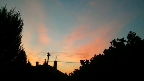 Low angle view of silhouette trees against sky at sunset