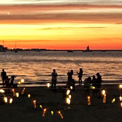 Silhouette people in water at sunset