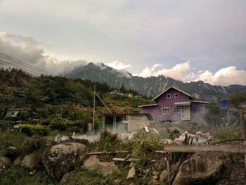 Scenic view of houses and mountains against sky