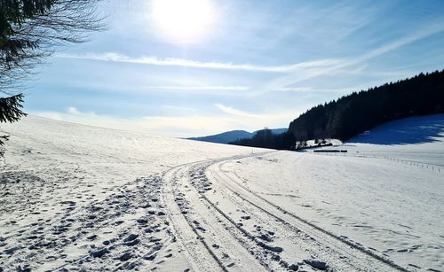 Scenic view of snow covered land against sky