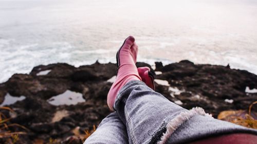 Low section of man relaxing at beach