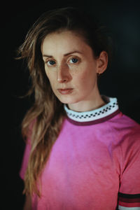 Portrait of beautiful woman standing against black background