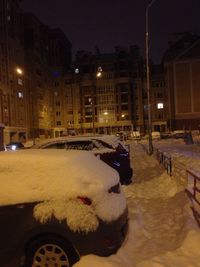 Cars parked on illuminated street during winter at night