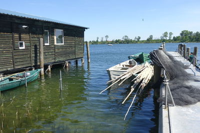 Wooden posts in lake against sky