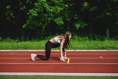 Side view of young woman running on landscape