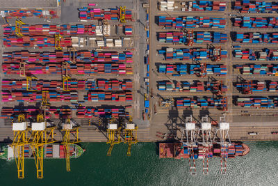 Container ship loading and unloading in sea port, aerial view of business logistic import and export 