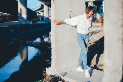 Young woman standing under bridge