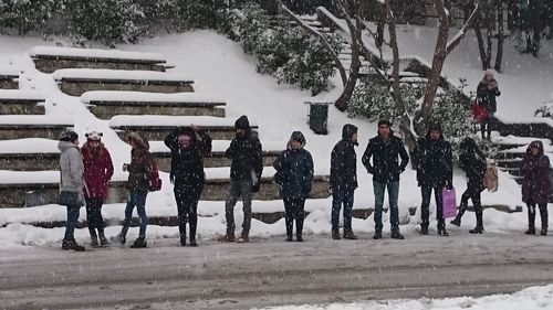 People standing on snow covered landscape