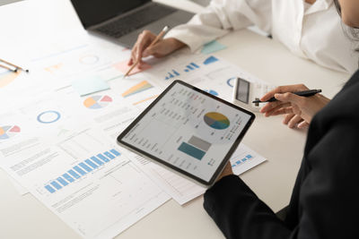 Midsection of business colleagues working on table