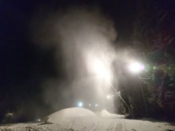 Snow covered landscape against sky at night