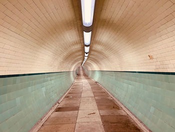 Rear view of man walking in tunnel