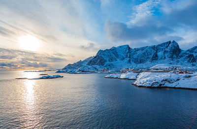Scenic view of sea and snowcapped mountains against sky