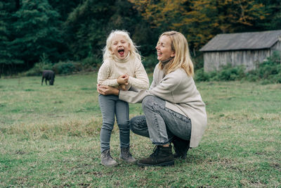 A loving mother tickles her laughing little daughter.