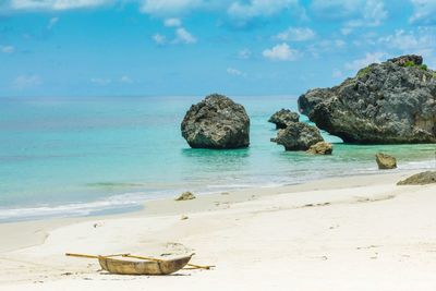 View of rocks on beach against sky