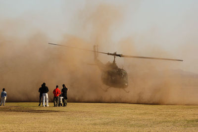 People standing on field against sky