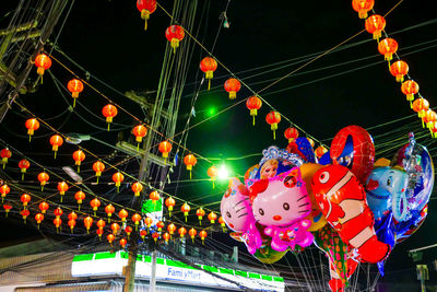 Low angle view of illuminated lanterns against sky at night